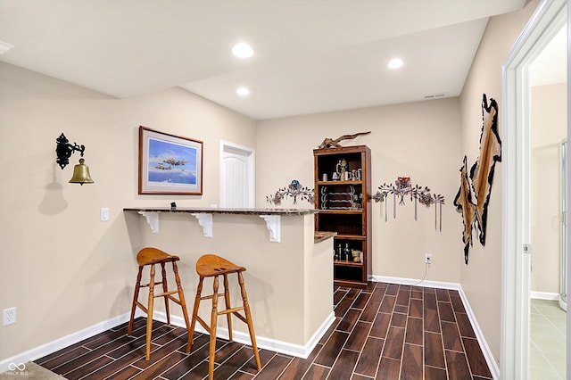 bar with wood finish floors, baseboards, and recessed lighting