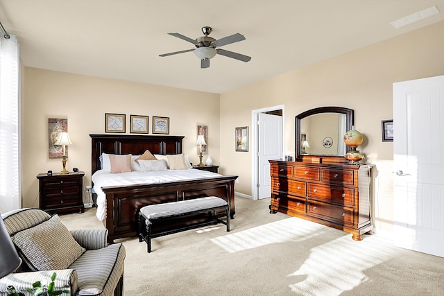 bedroom featuring a ceiling fan, light colored carpet, and visible vents