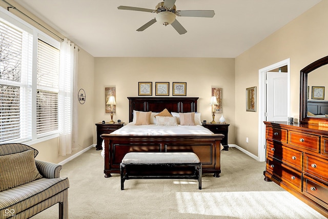 bedroom with light colored carpet, baseboards, and ceiling fan