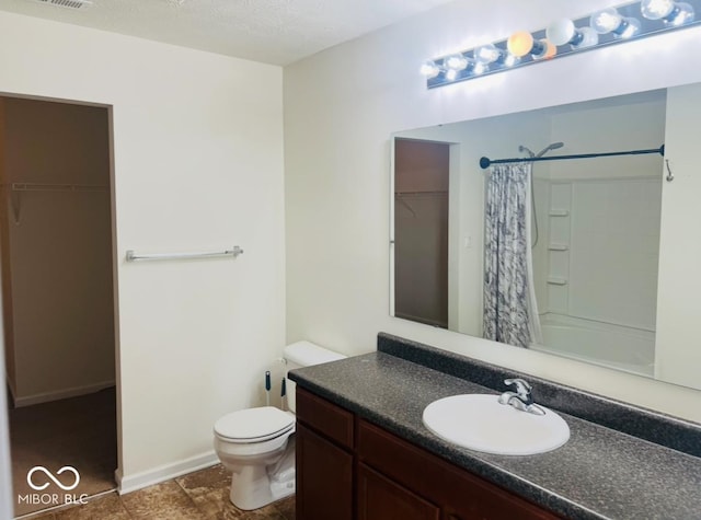 bathroom with a textured ceiling, toilet, a shower with shower curtain, vanity, and a spacious closet