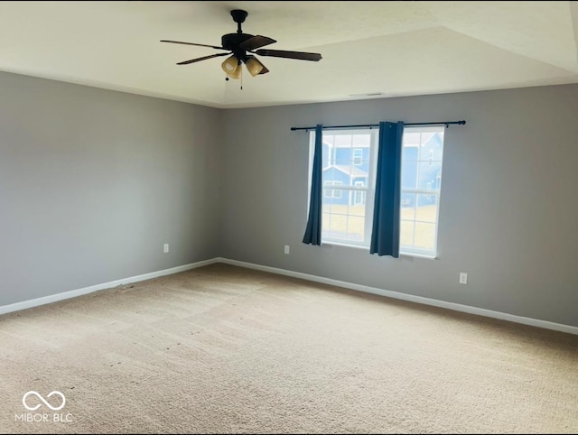 carpeted empty room with baseboards and a ceiling fan