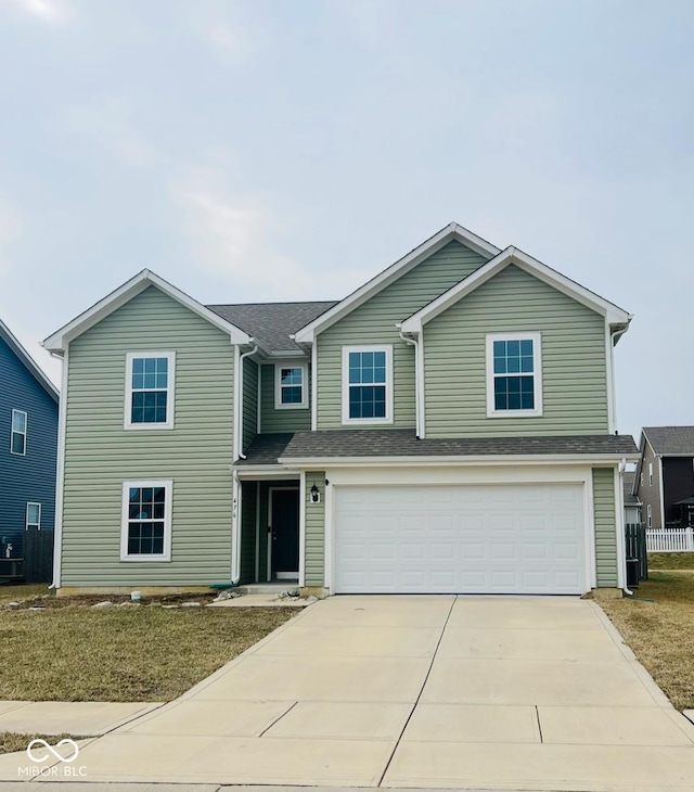 traditional-style home with a garage, driveway, and fence