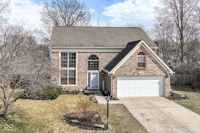 traditional-style house featuring driveway, a garage, a shingled roof, fence, and brick siding