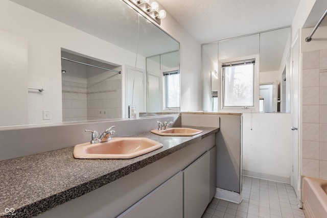 full bathroom with double vanity,  shower combination, tile patterned flooring, and a sink