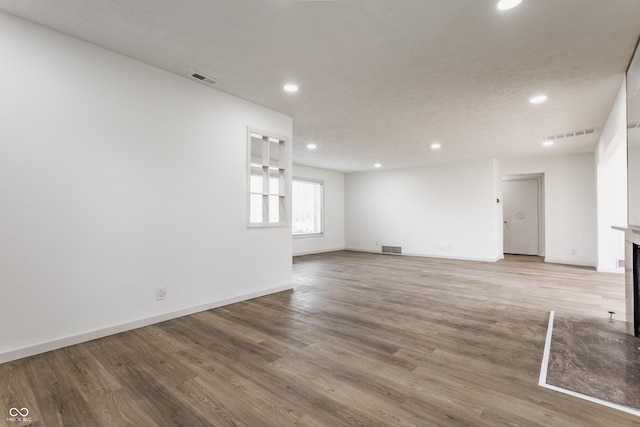 unfurnished room with light wood finished floors, recessed lighting, visible vents, and baseboards