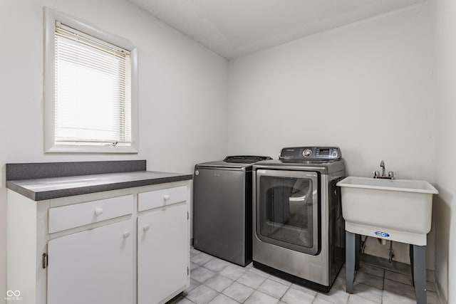 laundry room with cabinet space, a sink, and independent washer and dryer