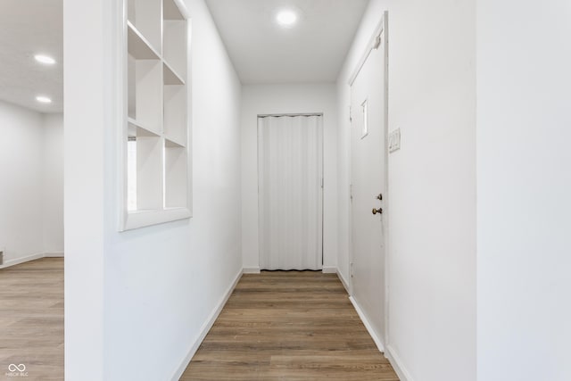 hallway featuring recessed lighting, baseboards, and wood finished floors