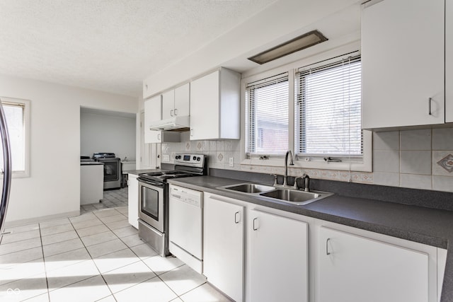 kitchen with dark countertops, a sink, stainless steel range with electric stovetop, and under cabinet range hood