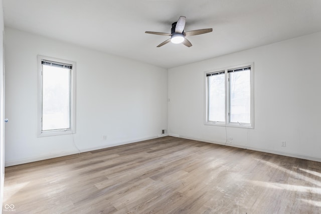 unfurnished room with light wood-style floors, visible vents, ceiling fan, and baseboards