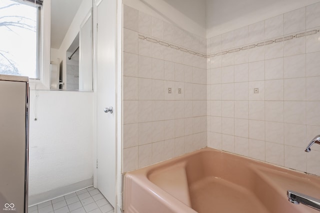 full bathroom with a bathing tub and tile patterned flooring