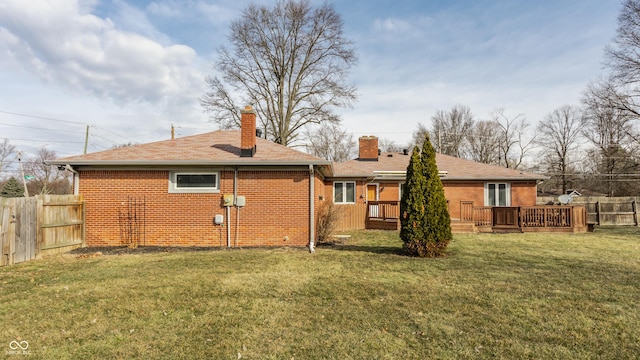 back of property featuring brick siding, a lawn, and fence