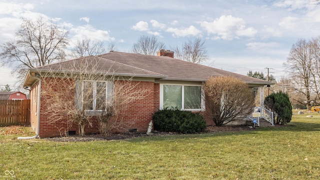 exterior space featuring brick siding, fence, a yard, crawl space, and a chimney