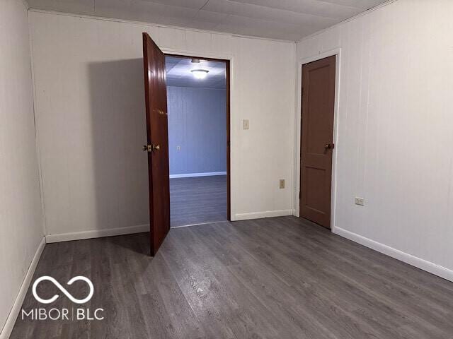 unfurnished room featuring baseboards and wood finished floors