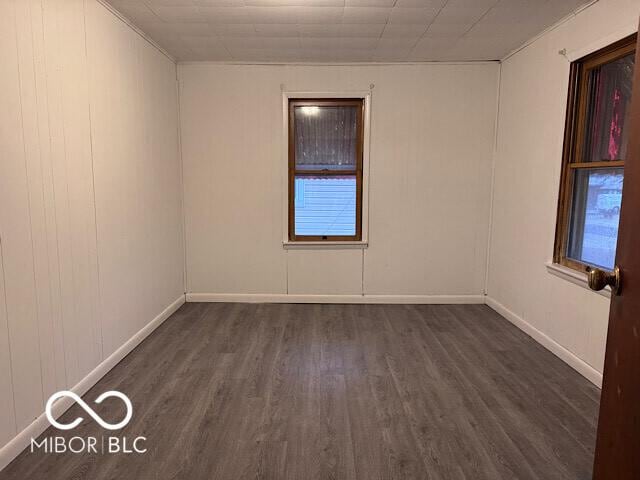 unfurnished room with dark wood finished floors and baseboards