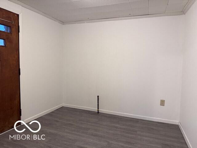 unfurnished room featuring dark wood-style floors, baseboards, and crown molding