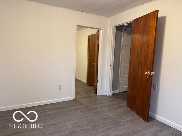 empty room with baseboards and dark wood-style flooring