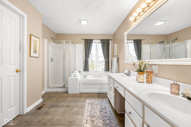 bathroom featuring a garden tub, double vanity, a stall shower, a sink, and tile patterned floors