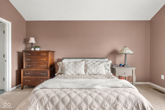 bedroom with light carpet, visible vents, baseboards, and a textured ceiling