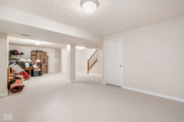 finished basement featuring carpet floors, a textured ceiling, and baseboards