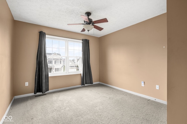 carpeted spare room with a textured ceiling, a ceiling fan, visible vents, and baseboards