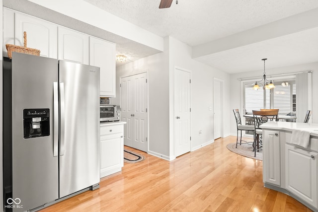 kitchen with stainless steel refrigerator with ice dispenser, light countertops, light wood-style flooring, white cabinetry, and a textured ceiling