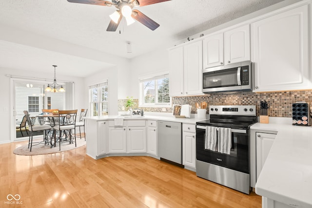 kitchen with appliances with stainless steel finishes, light wood-style flooring, and white cabinetry