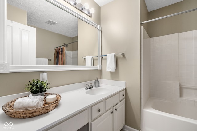 full bathroom featuring shower / bath combination with curtain, visible vents, a textured ceiling, and vanity