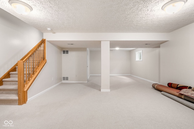 basement featuring light carpet, stairway, and visible vents