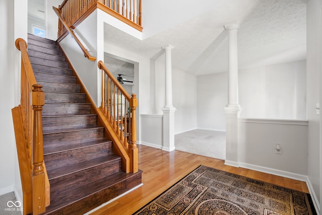 11866 Weathered Edge Dr, Fishers, IN 46037 - staircase with wood finished floors, ceiling fan, a textured ceiling, baseboards, and ornate columns