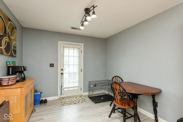 dining space with light wood-type flooring, baseboards, and visible vents