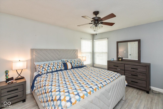 bedroom featuring a textured ceiling, wood finished floors, and baseboards