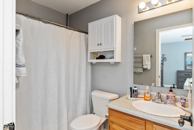 bathroom featuring toilet, a textured ceiling, and vanity