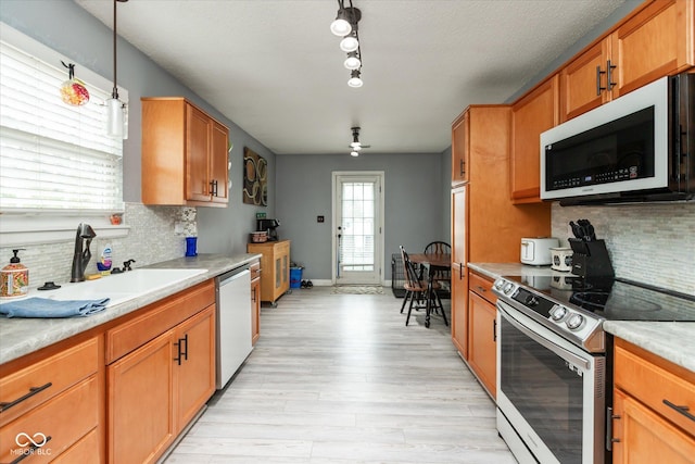 kitchen featuring dishwasher, light countertops, white microwave, and stainless steel range with electric cooktop