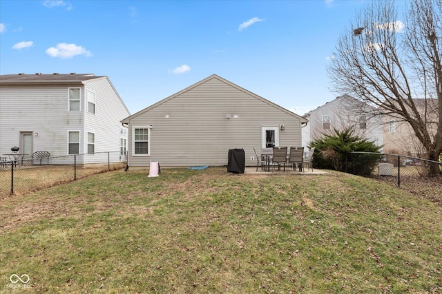 rear view of house featuring a fenced backyard, a lawn, and a patio