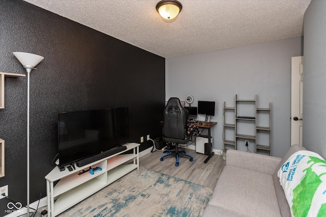 office space featuring a textured ceiling, baseboards, and wood finished floors