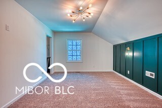 bonus room featuring vaulted ceiling and carpet flooring