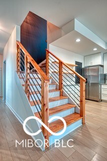 stairs with wood finished floors and recessed lighting