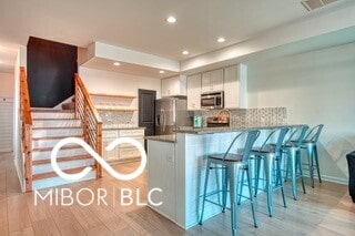 kitchen featuring a peninsula, wood finished floors, visible vents, appliances with stainless steel finishes, and backsplash