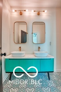 bathroom with double vanity, baseboards, and a sink