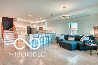 living area with a notable chandelier, stairway, wood finished floors, and recessed lighting