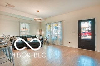 living room with baseboards, visible vents, and wood finished floors