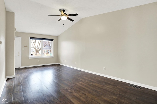 spare room with lofted ceiling, ceiling fan, visible vents, baseboards, and dark wood finished floors