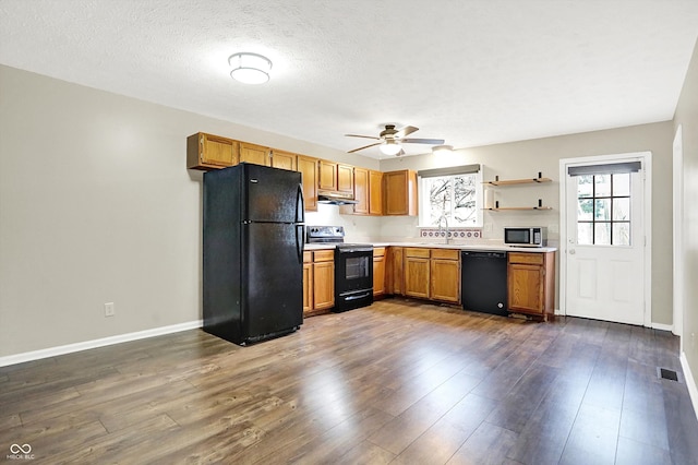 kitchen featuring dark wood-type flooring, light countertops, visible vents, and black appliances