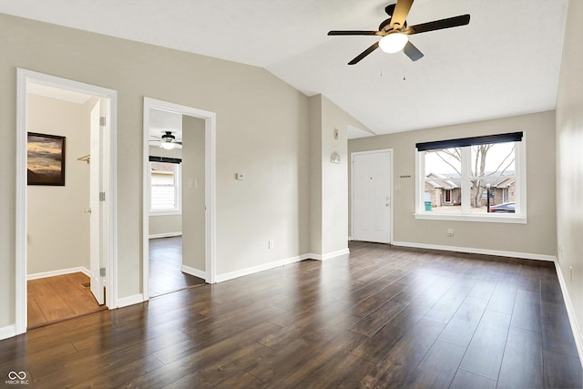 interior space with dark wood-type flooring, lofted ceiling, baseboards, and a ceiling fan