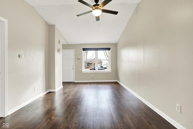 unfurnished room featuring dark wood-style floors, vaulted ceiling, ceiling fan, and baseboards