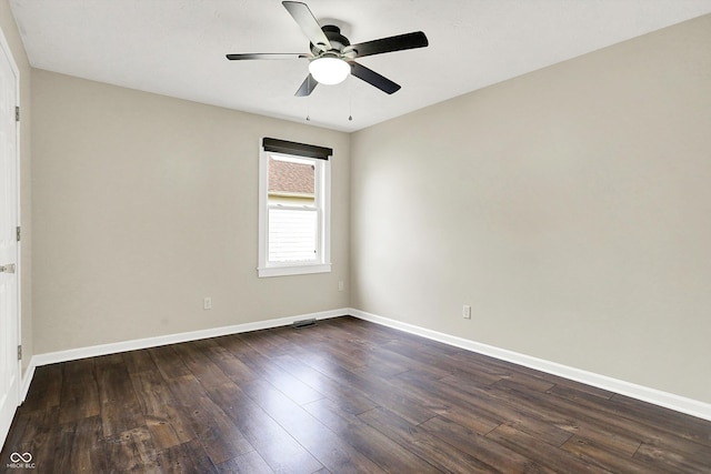 empty room with dark wood-type flooring, a ceiling fan, and baseboards