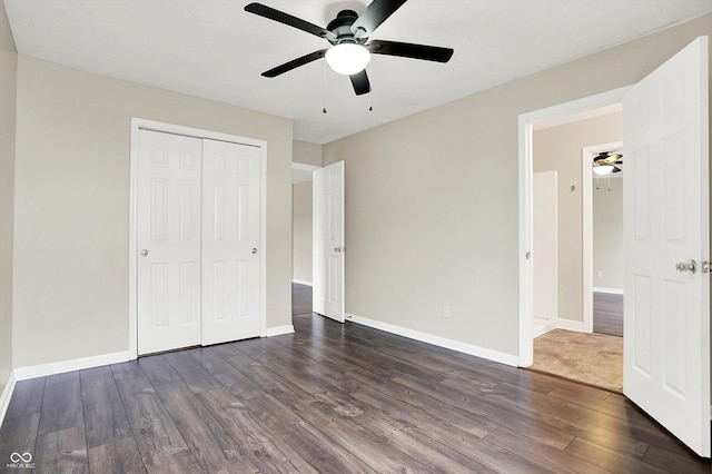 unfurnished bedroom with a ceiling fan, a closet, baseboards, and dark wood-type flooring