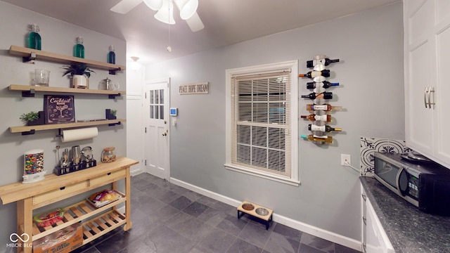 doorway to outside featuring baseboards and a ceiling fan