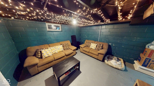 unfurnished living room with concrete flooring and concrete block wall