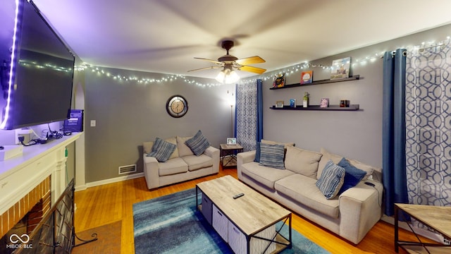 living area featuring wood finished floors, visible vents, and a ceiling fan